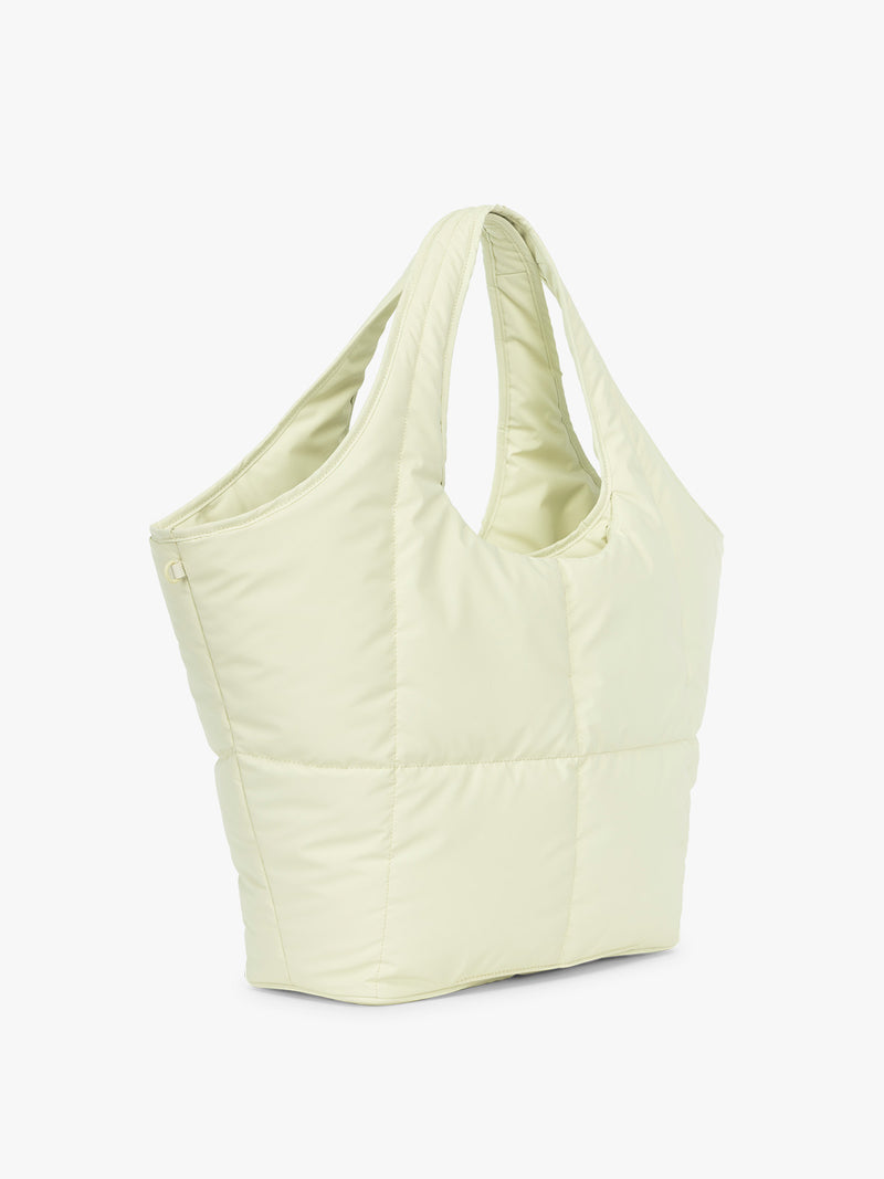 Side view of CALPAK Luka Everything Laptop Tote in light green Celadon with shoulder strap on a white background