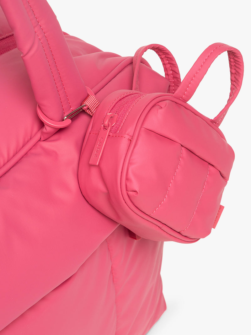 Close up of CALPAK Luka Duffel Zip Bag Charm in bright pink Dragonfruit on the CALPAK Luka Mini Duffel in bright pink Dragonfruit