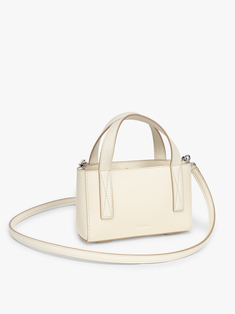 Side view of CALPAK Haven Mini Crossbody Bag in beige Buttercream