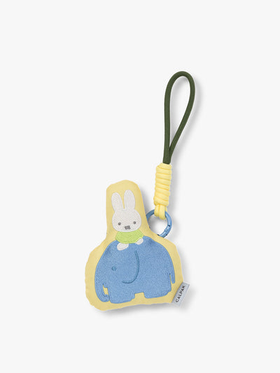 Plush Miffy x CALPAK Pluffy Bag Charm keychain with a yellow border and Miffy on a blue elephant on a white background; APLF2501-MIFFY-ELEPHANT view 1