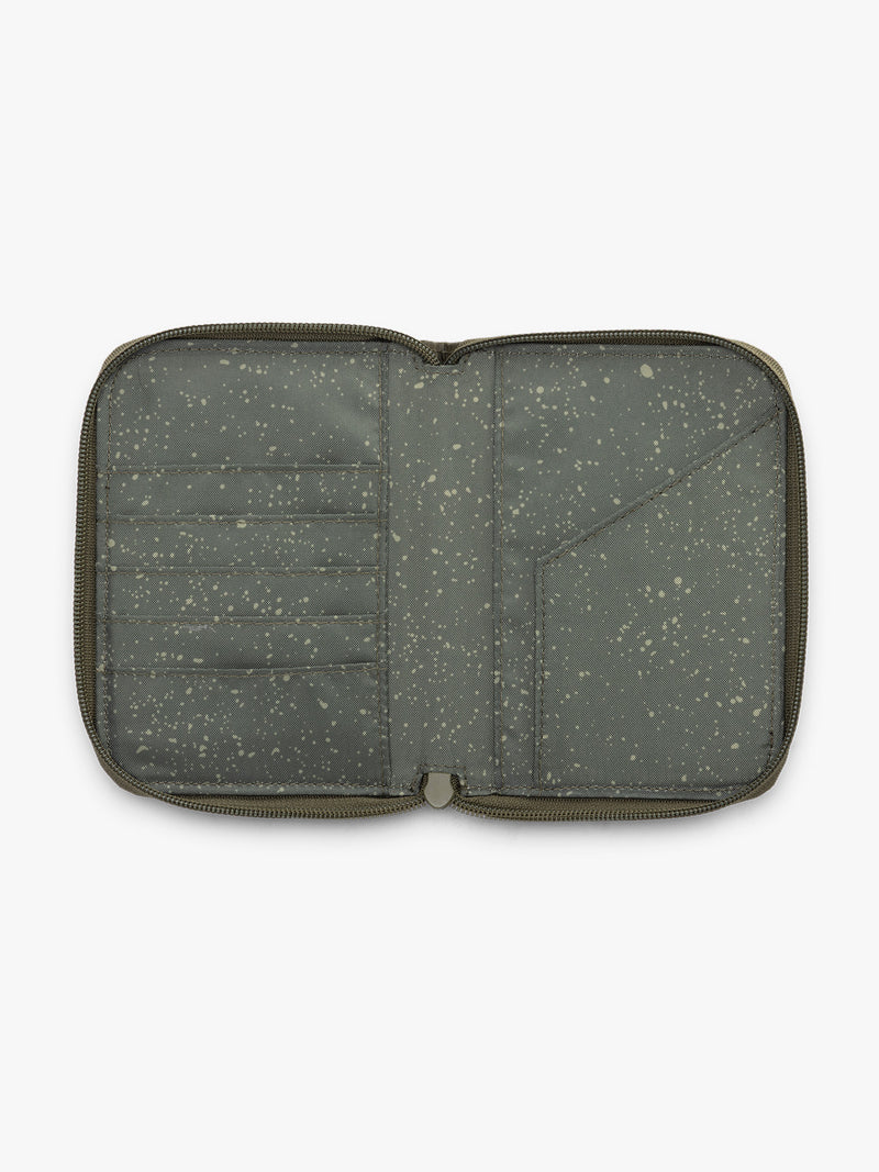 Model with CALPAK Terra Zip Passport Wallet in green Pine opened