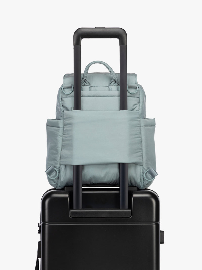 CALPAK Convertible Mini Diaper Backpack in light blue Bluebell on luggage with trolley sleeve