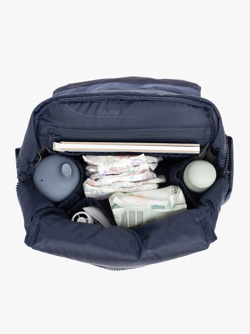 Baby items inside CALPAK Mini Diaper Backpack in blue Navy