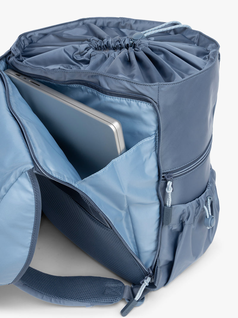 Laptop sleeve on the back of CALPAK Fit Gym Backpack in blue Indigo with white background