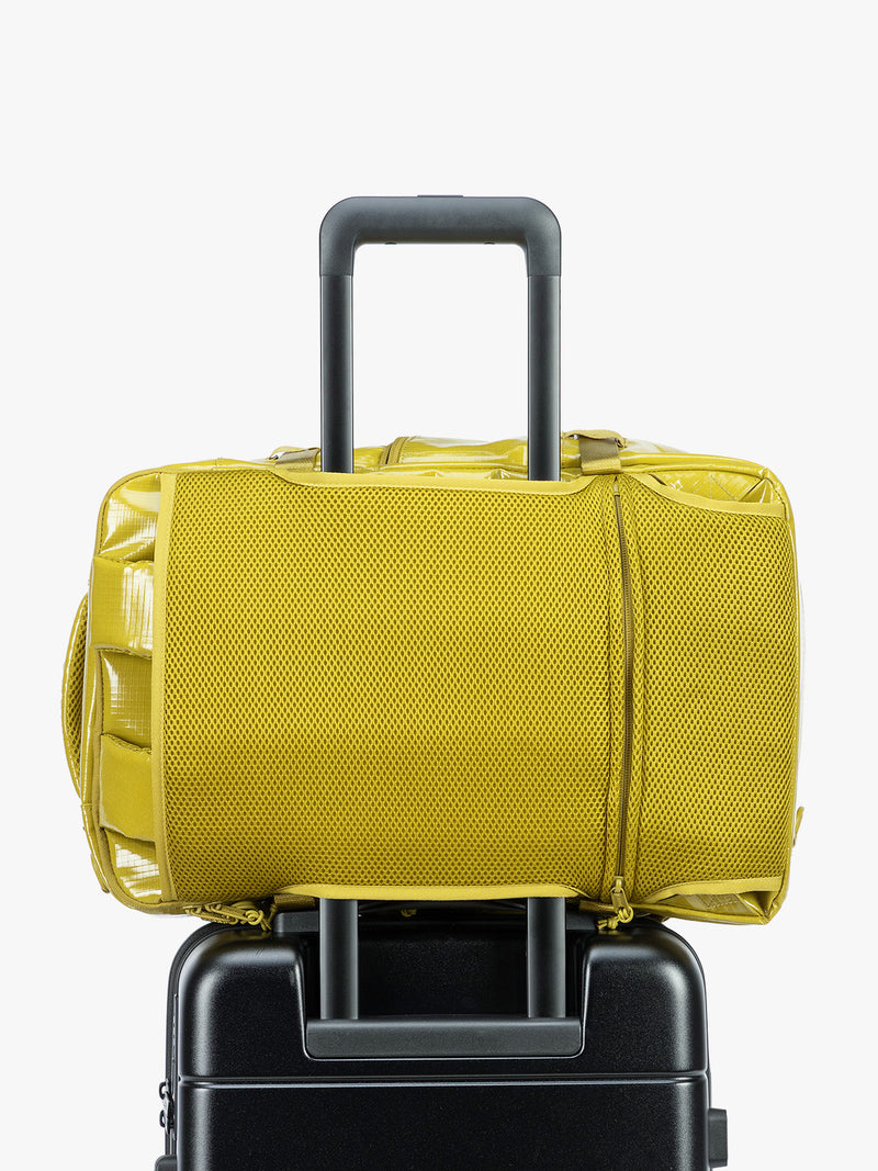 Backside trolley sleeve of CALPAK Terra 26L Laptop Backpack in yellow green Wasabi with multiple pockets on a white background