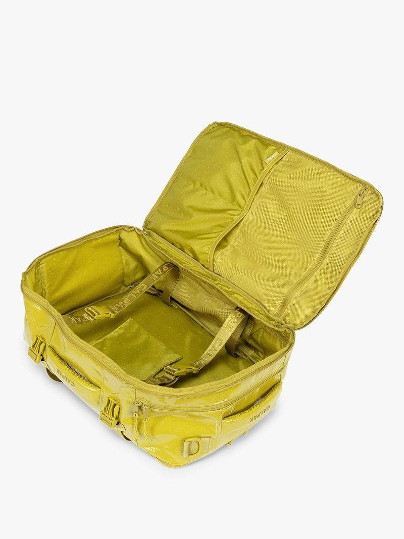 Opened CALPAK Terra 26L Laptop Backpack in yellow green Wasabi with multiple pockets on a white background