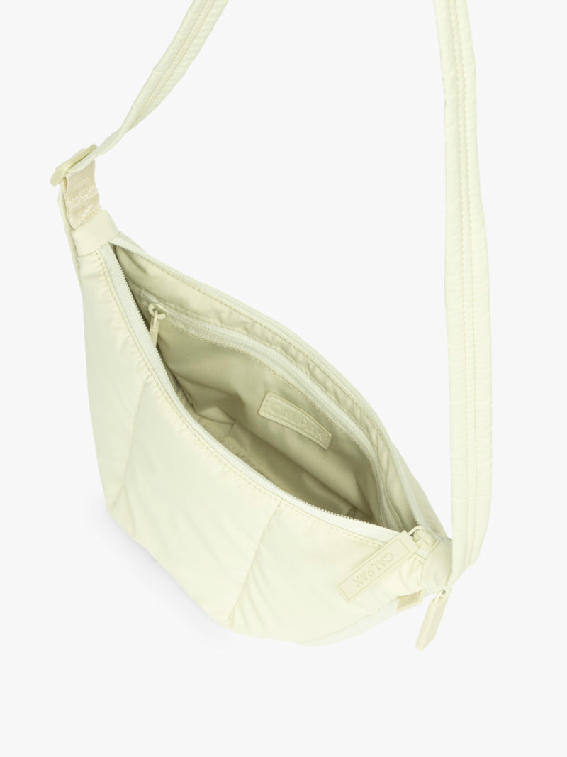 Opened interior of CALPAK Luka Crescent Tote bag in light green Celadon with shoulder strap and bag is expandable up to 2" on a white background