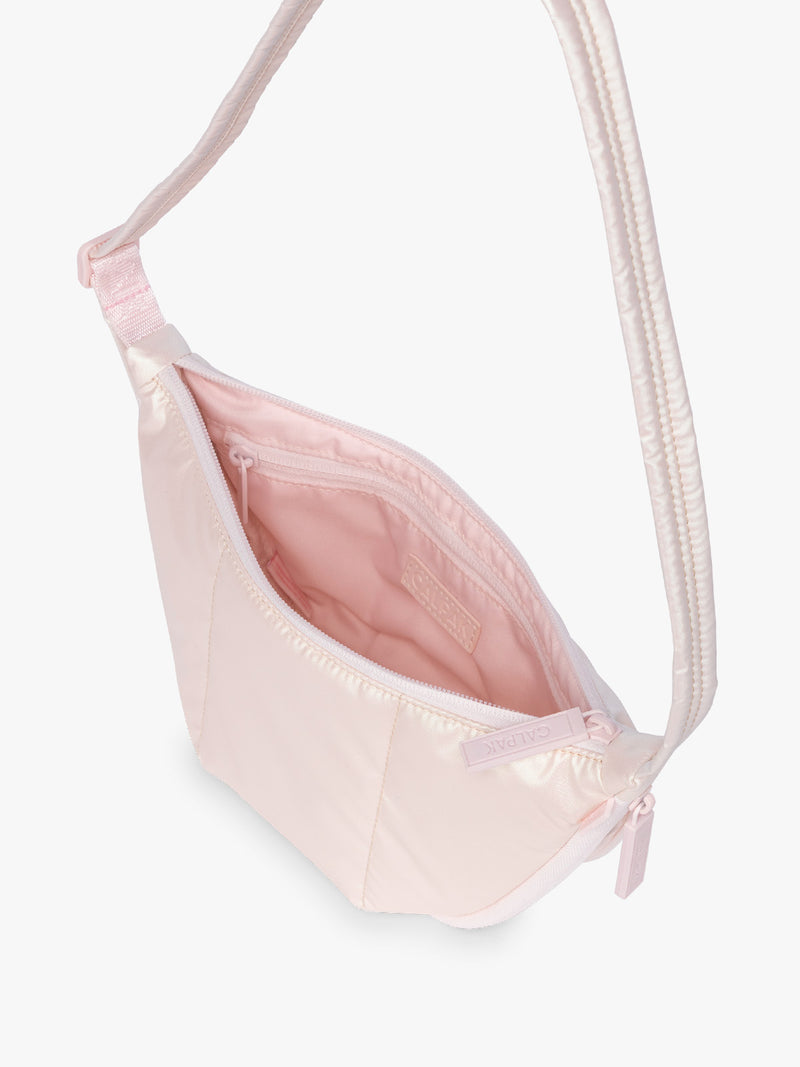 Opened CALPAK Luka Crescent Bag in light pink shiny Pearlescent