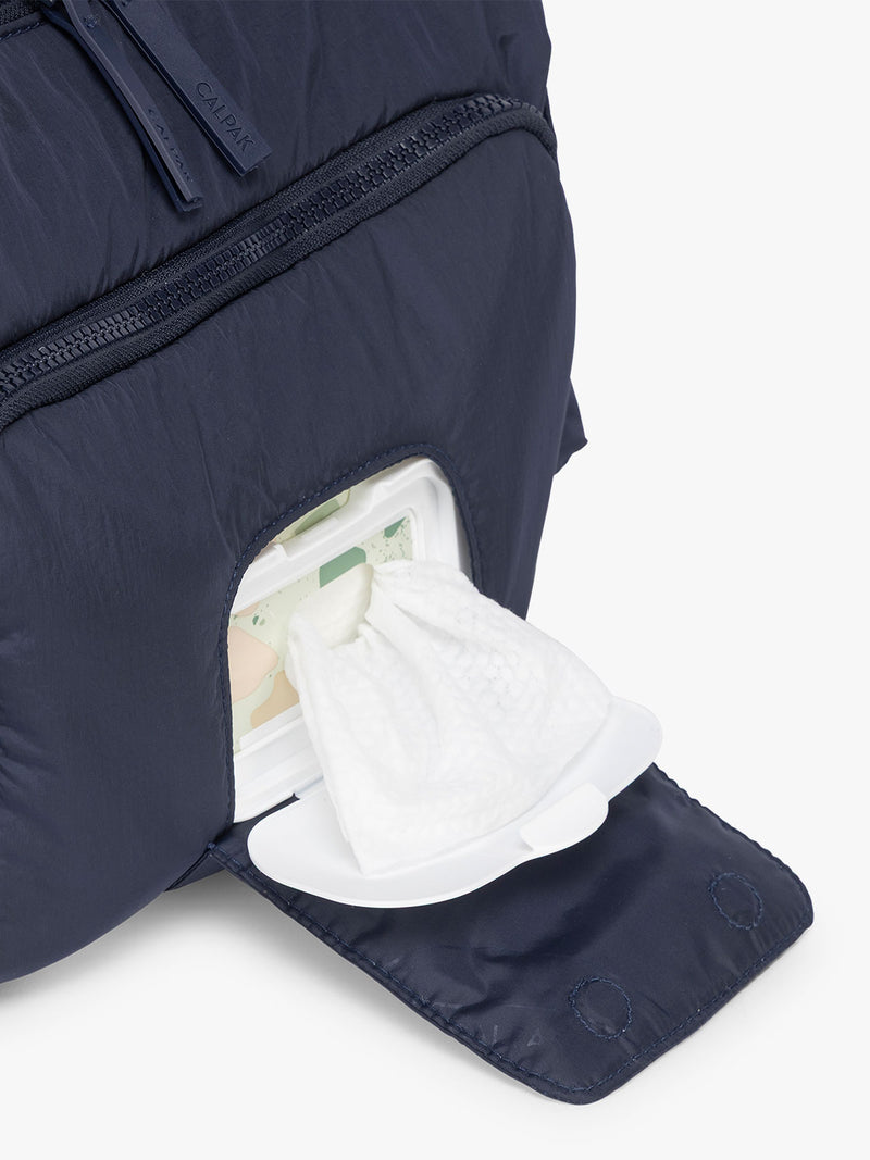 Close up of the front smart wipe compartment of the CALPAK Crossbody Diaper Bag in blue Navy