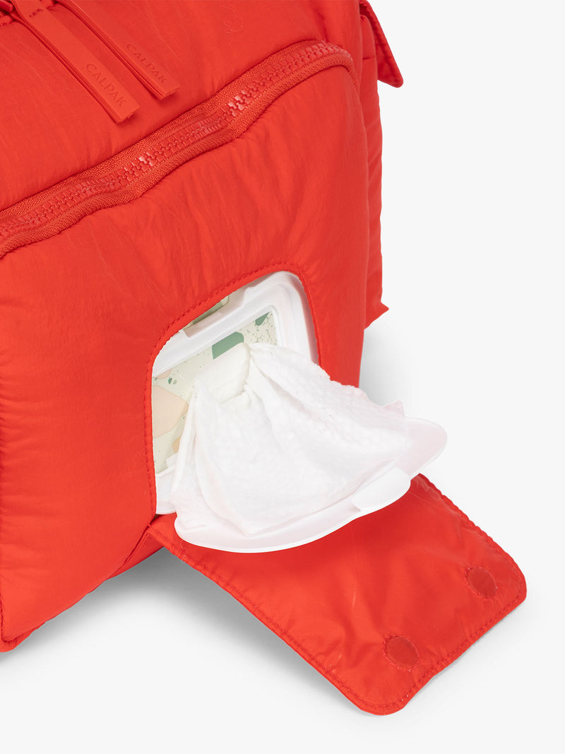 Front smart compartment for wipes in the CALPAK Crossbody Diaper Bag in red Tomato