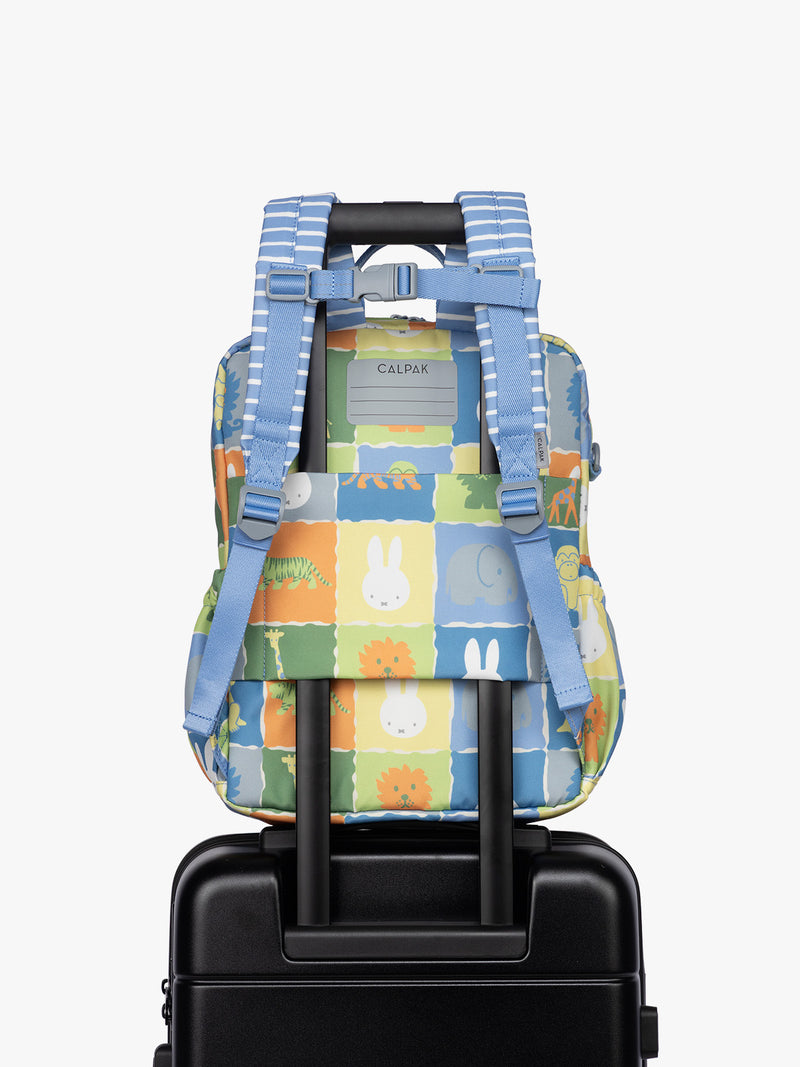 Back luggage trolley sleeve of  CALPAK Kids Medium Backpack with Miffy and blue colorful animal pattern on a white background