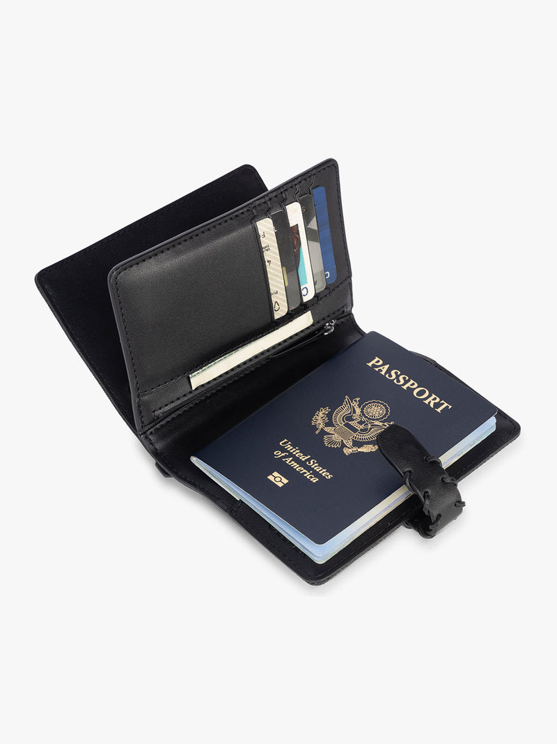 Opened with passport with card slots of CALPAK Colette Multi Passport Wallet in Black canvas material