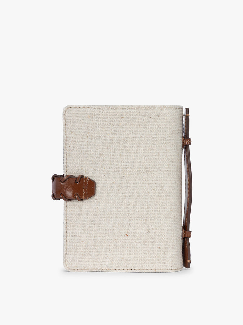 Back side of CALPAK Colette Multi Passport Wallet in beige canvas material and brown finishings in Natural Brown