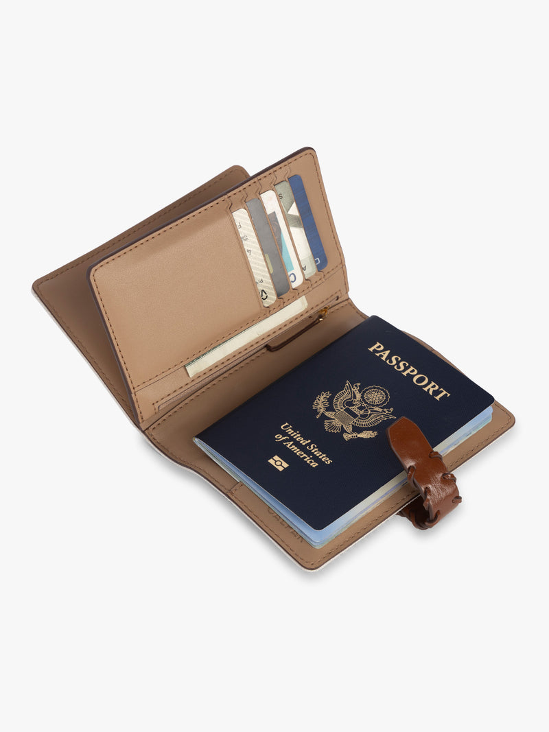 Opened with passport and card slots of CALPAK Colette Multi Passport Wallet in beige canvas material and brown finishings in Natural Brown