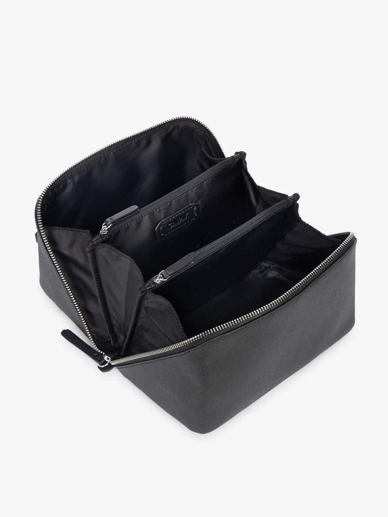 Opened CALPAK Colette Lay-Flat Canvas Toiletry Bag in black canvas material laid open flat