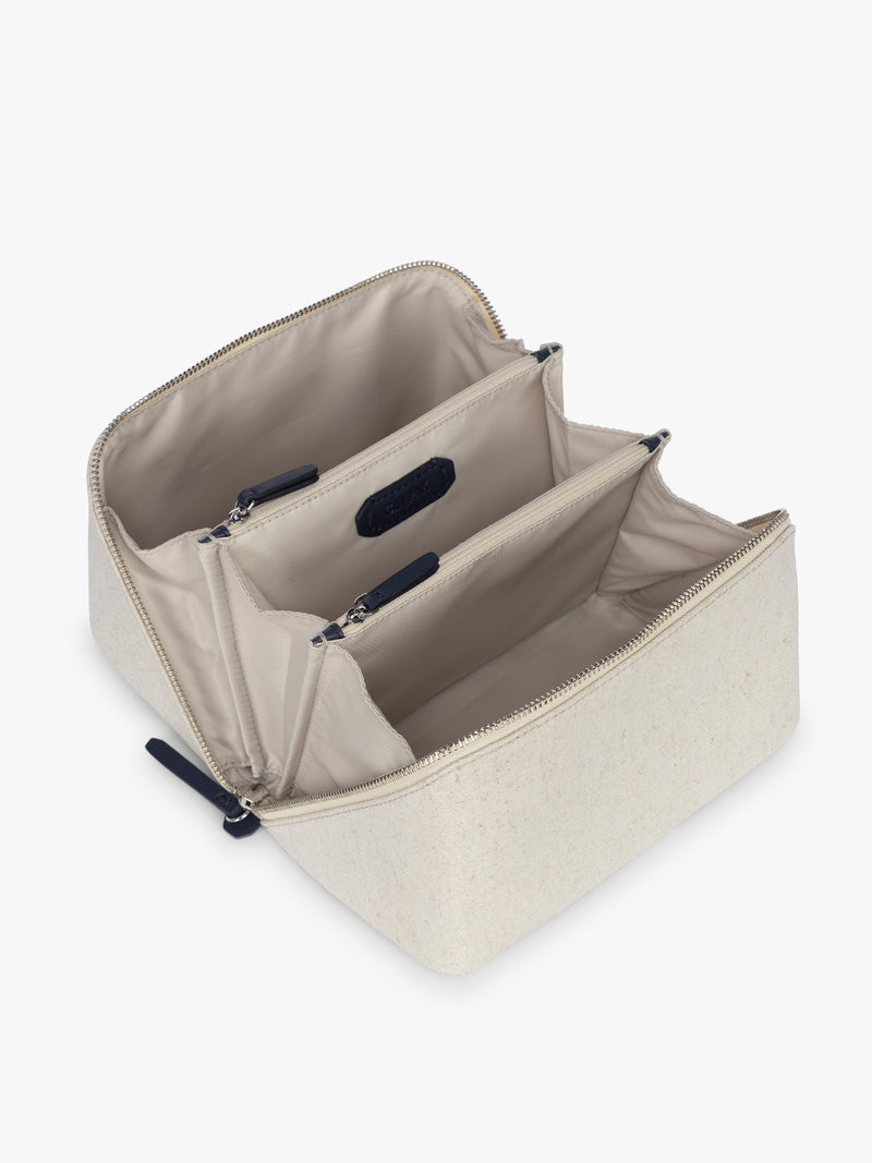 Opened CALPAK Colette Lay-Flat Canvas Toiletry Bag in beige canvas  material and blue finishing