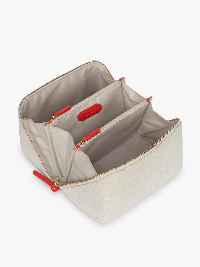 Opened CALPAK Colette Lay-Flat Canvas Toiletry Bag in beige canvas material and red finishing