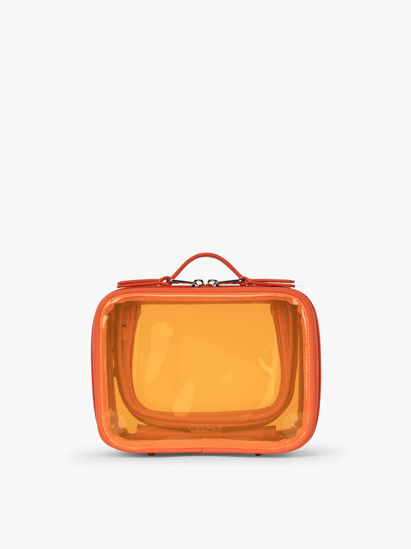 CALPAK x Dedcool Collaboration of the Small Clear Cosmetic Case in orange Papaya with toiletry items and perfumes  on a airport chair