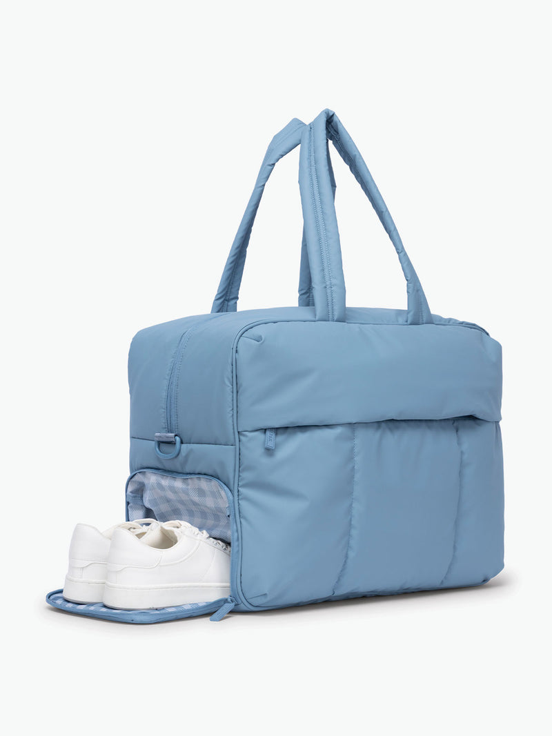 Bottom shoe compartment of  CALPAK Luka Large duffel bag in French Blue with zippered closure