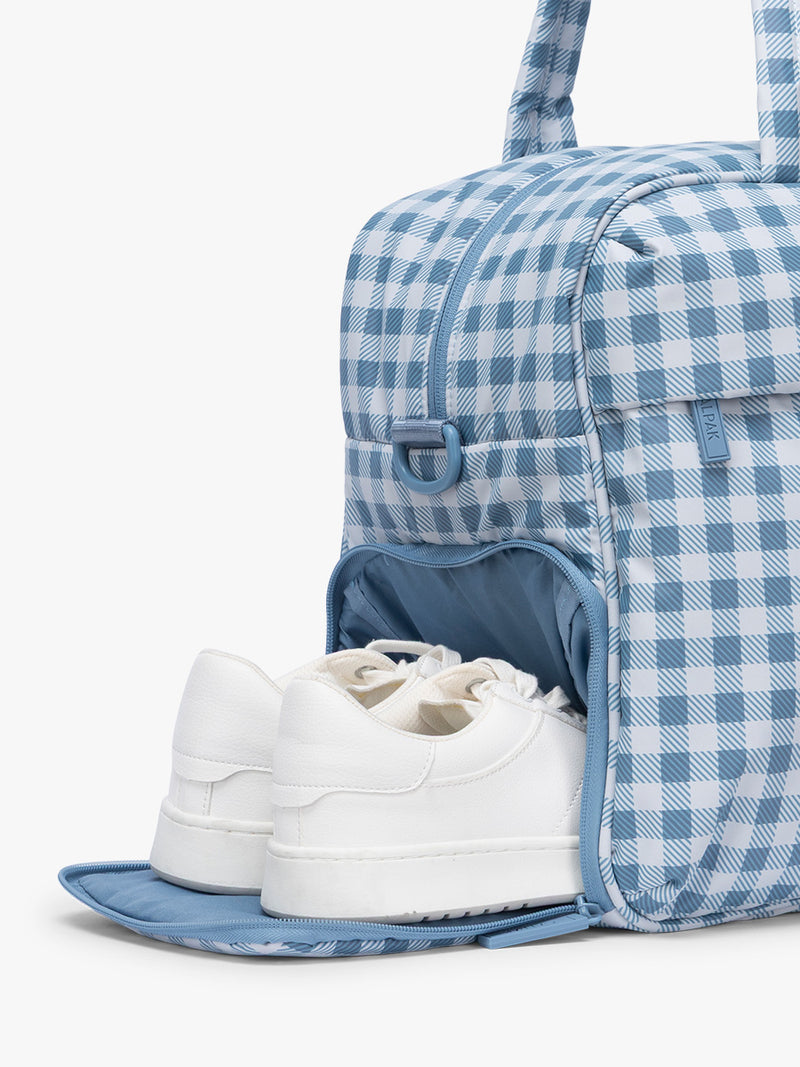 Shoe compartment of CALPAK Luka Duffel in white and blue gingham print in French Blue Gingham