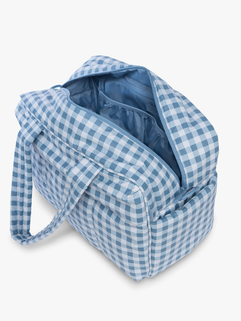Opened view of CALPAK Luka Duffel in white and blue gingham print in French Blue Gingham