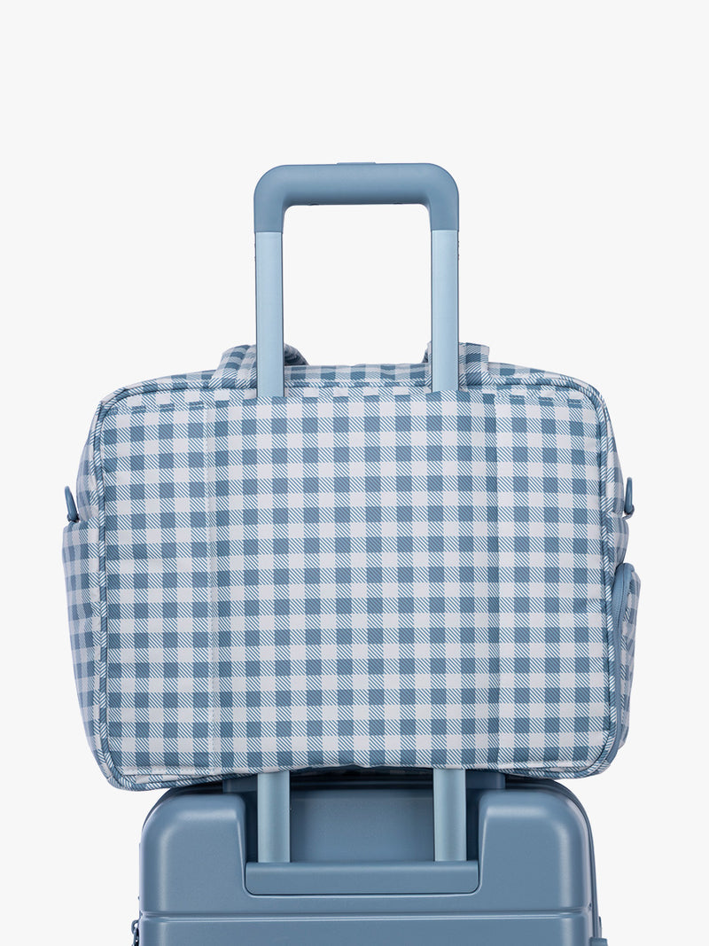 Luggage trolley sleeve of CALPAK Luka Duffel in white and blue gingham print in French Blue Gingham