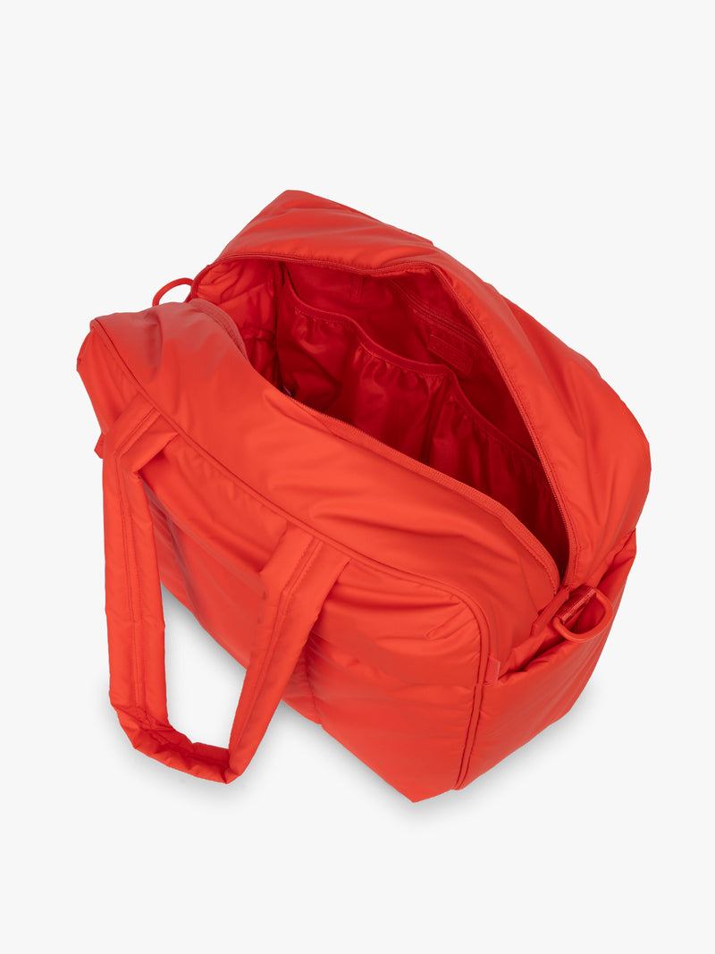 Opened CALPAK Luka Duffel in red Tomato