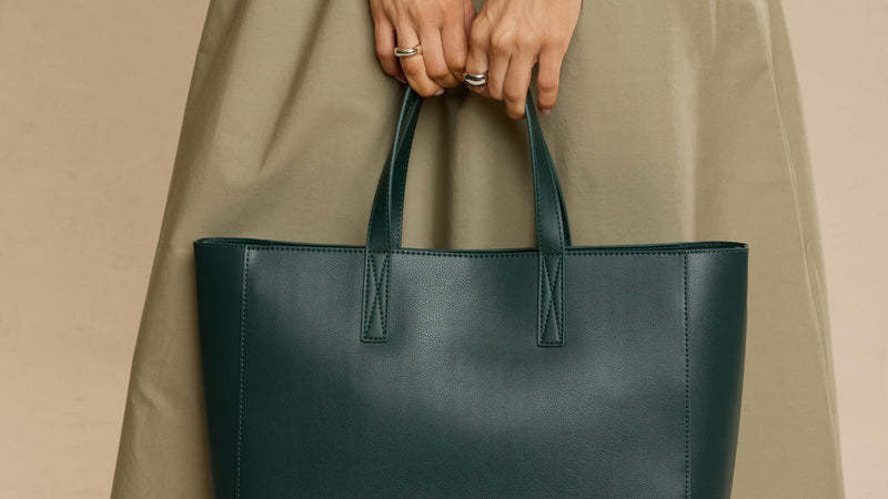 CALPAK Haven dark green Forest Haven tote bag held by a person against a beige background