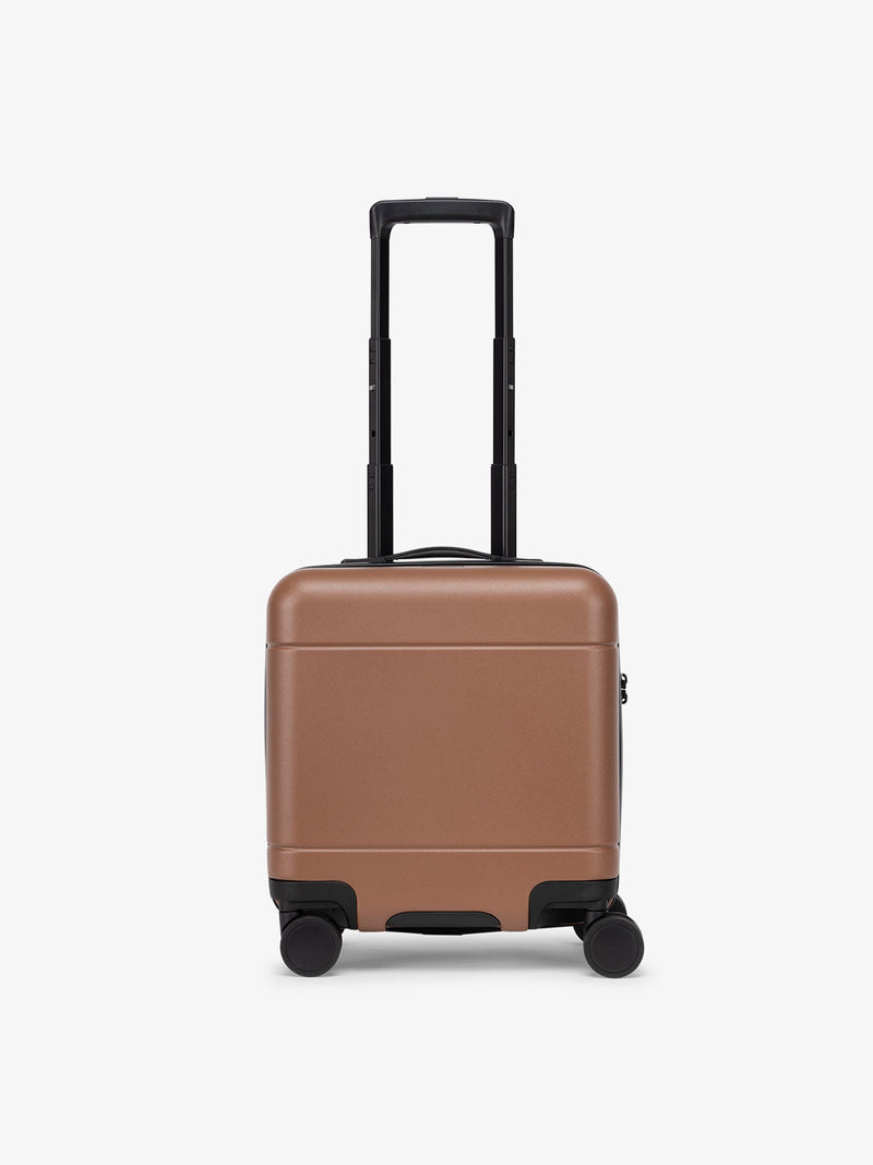 A front view of the Hue Mini Carry-On Luggage in a hazel brown color. The suitcase features a hard-shell design with smooth, rounded edges, zipper closure, and a top handle