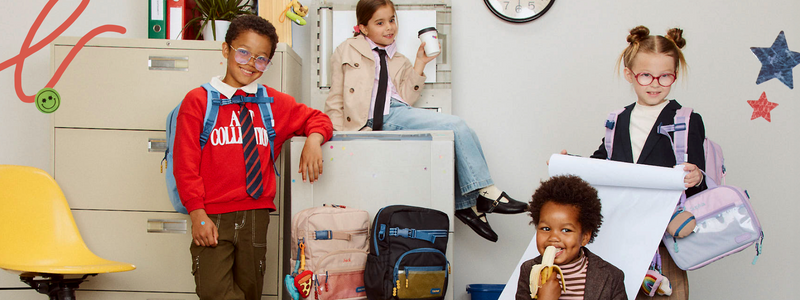Children with school supplies and CALPAK bags in a classroom setting