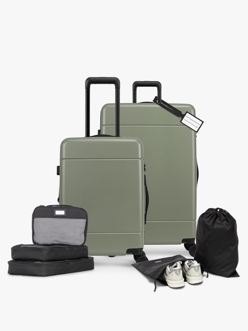 CALPAK Hue Starter Bundle in green Juniper that comes with Large and Carry On Luggage, Luggage Tag, Two Black Pouches, and Three Black Packing Cubes shown on a white background