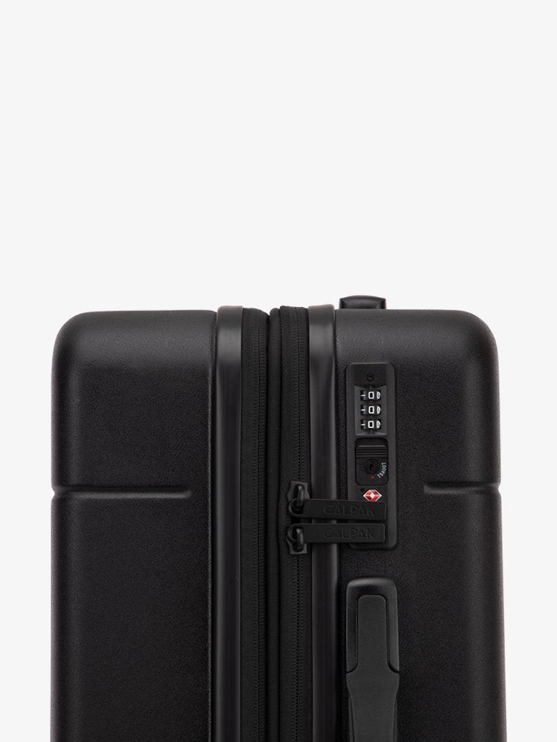 TSA-approved lock on the CALPAK Hue Starter Bundle in Black that comes with Large and Carry On Luggage with op handle on a white background