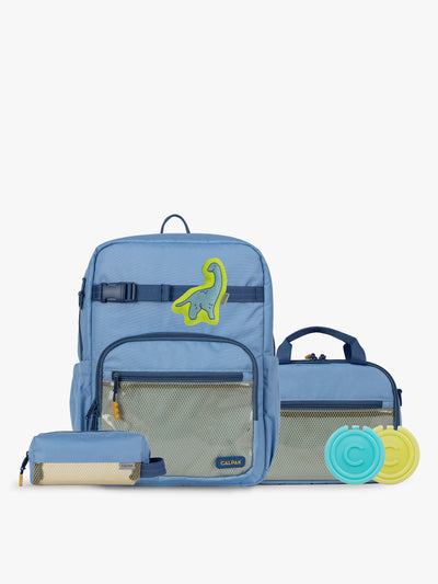 CALPAK Kids Collection Large Kids Backpack Bundle in Blue that includes Kids Lunch Bag, Kids Pencil Case, Rainbow Pluffy Bag Charm, and Set of 2 Ice Packs in a kid's room; BCKL5000-BLUE view 1
