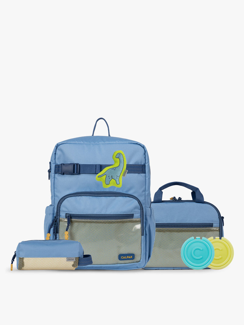 CALPAK Kids Collection Medium Kids Backpack Bundle in Blue that includes Kids Lunch Bag, Kids Pencil Case, blue and green Dinosaur Pluffy Bag Charm, and Set of 2 Ice Packs in a kid's room