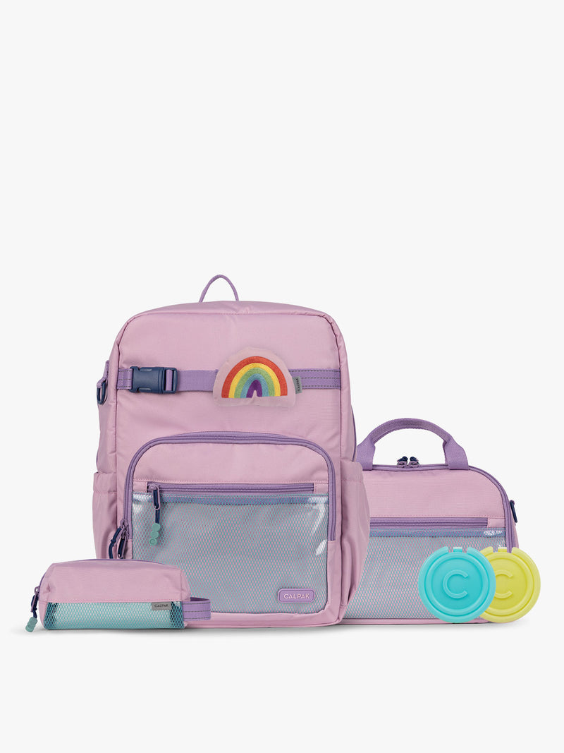 CALPAK Kids Collection Large Kids Backpack Bundle in pink lavender Orchid Pink that includes Kids Lunch Bag, Kids Pencil Case, Rainbow Pluffy Bag Charm, and Set of 2 Ice Packs in a kid's room