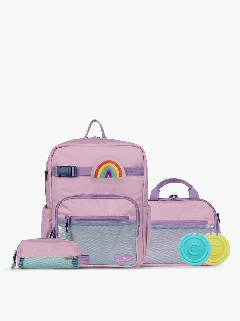CALPAK Kids Collection Medium Kids Backpack Bundle in pink lavender Orchid Pink that includes Kids Lunch Bag, Kids Pencil Case, Rainbow Pluffy Bag Charm, and Set of 2 Ice Packs in a kid's room