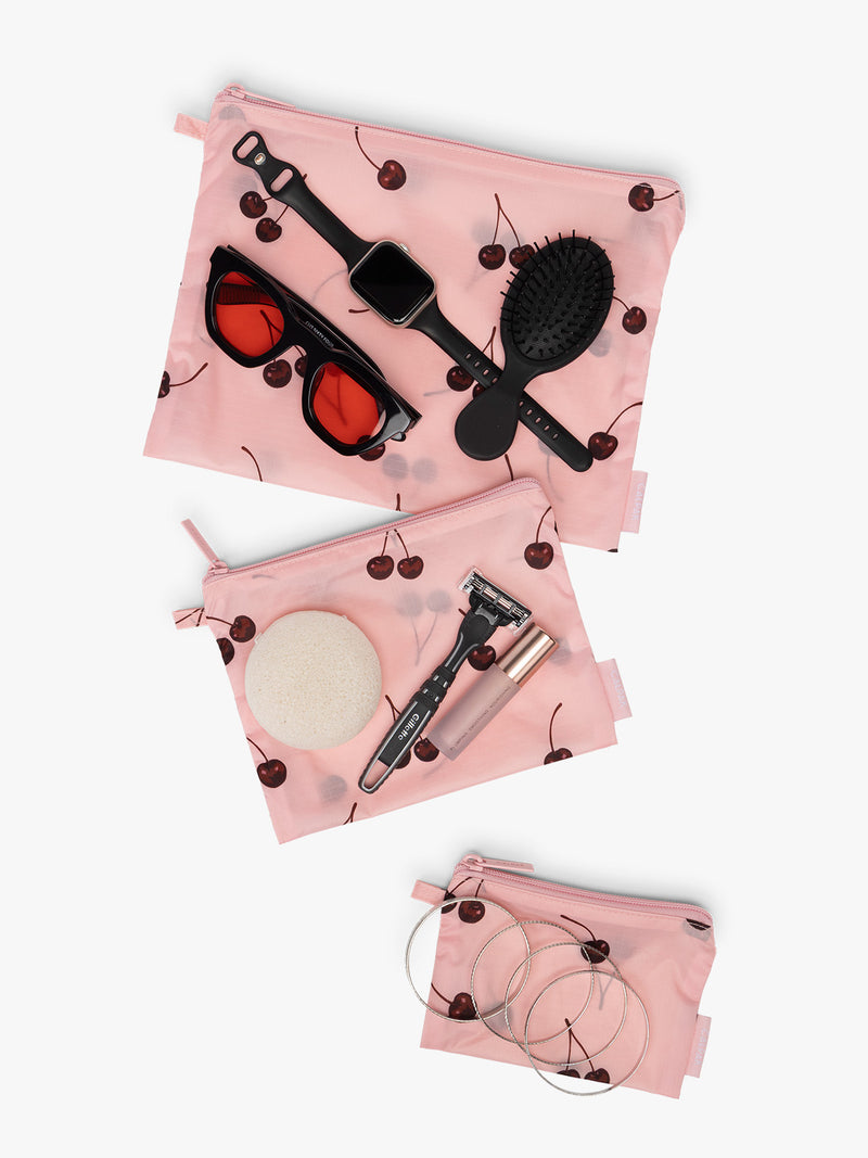 CALPAK  Compakt Zippered Pouch in pink with cherry pattern with items inside