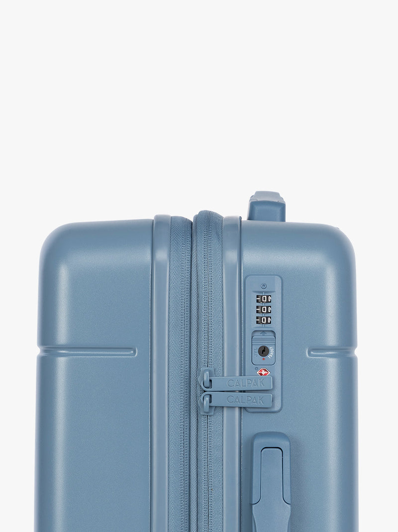 Side view with TSA lock of CALPAK Hue Medium Luggage in light blue French Blue and blue and white gingham interior