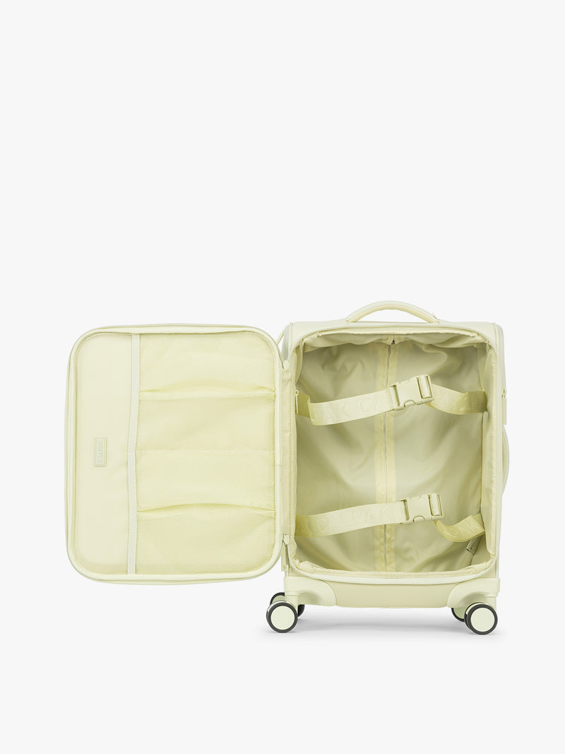 Opened showing interior of the CALPAK Luka Soft-Sided Carry On Luggage in light green Celadon on a white background with handle and spinner wheels