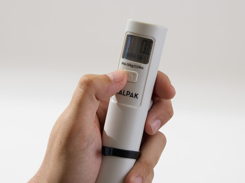 Model pressing M/T button of CALPAK Battery-Free Luggage Scale used to set up scale units 