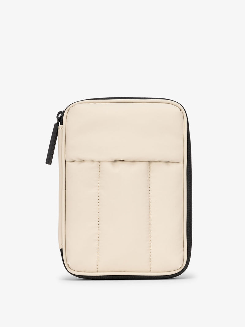  A front view of the Luka Zippered Passport Wallet in a light oatmeal color. The wallet features a minimalist design with a zipper closure, offering secure storage for travel essentials such as passports, cards, and documents