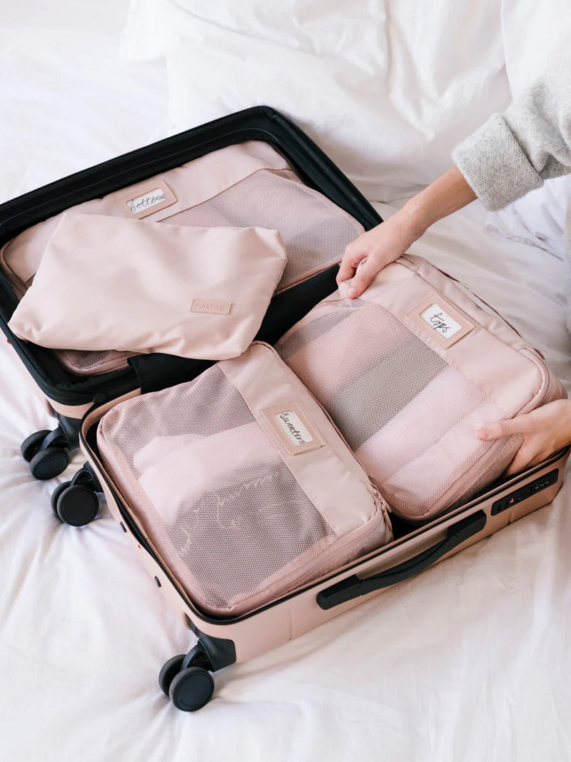 Model packing CALPAK packing pink CALPAK packing  cubes in a carry-on luggage
