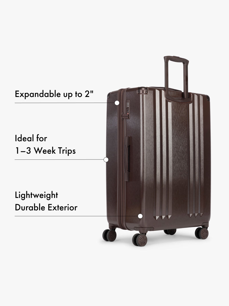 CALPAK large brown suitcase with text highlighting features on a white background
