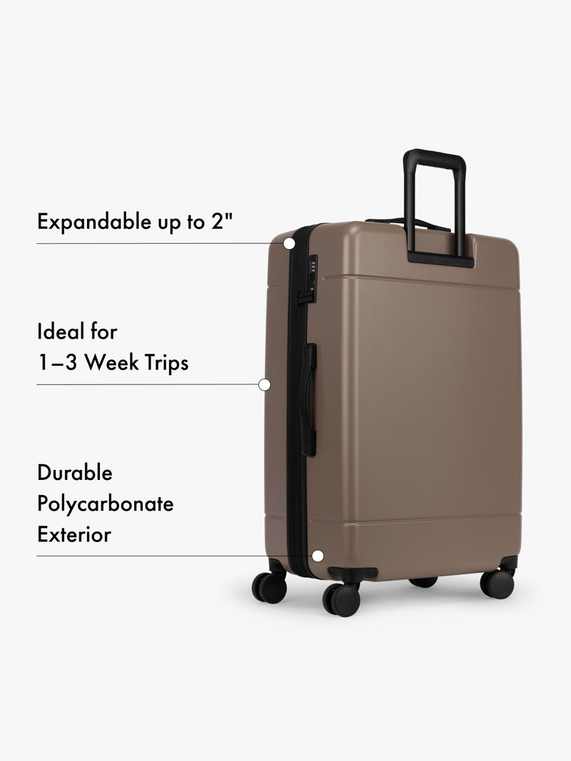 CALPAK Hue Large Luggage in brown chocolate with text highlighting features on a white background