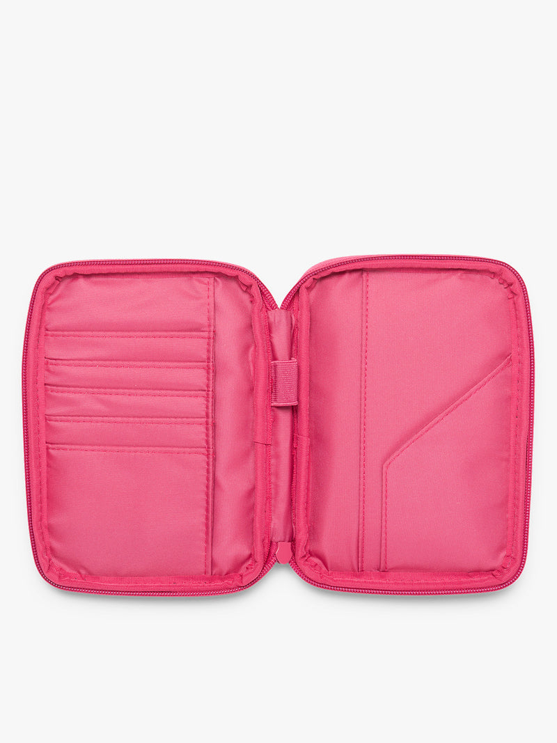 Opened interior of CALPAK Luka Zip Passport Wallet in bright pink Dragonfruit on a white background