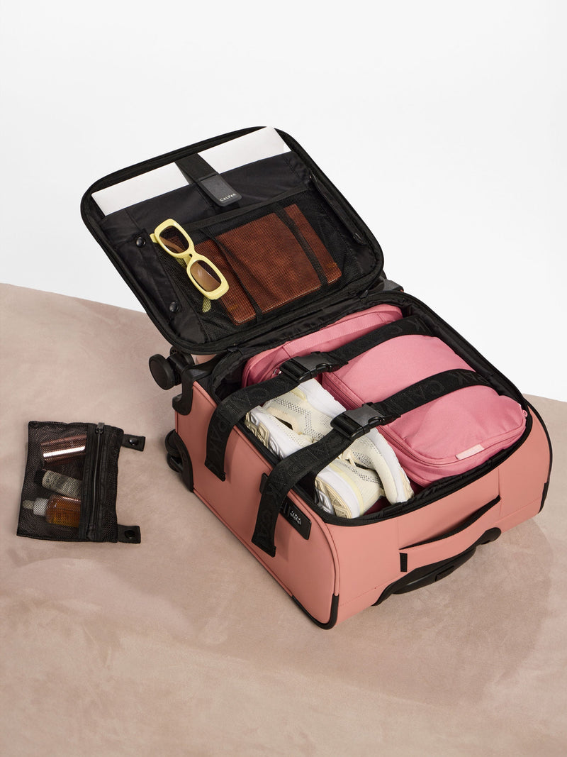 A lifestyle image of two medium compression packing cubes in light brown, displayed inside a suitcase. The cubes neatly store clothing, showcasing their space-saving design and functionality for organized packing during travel
