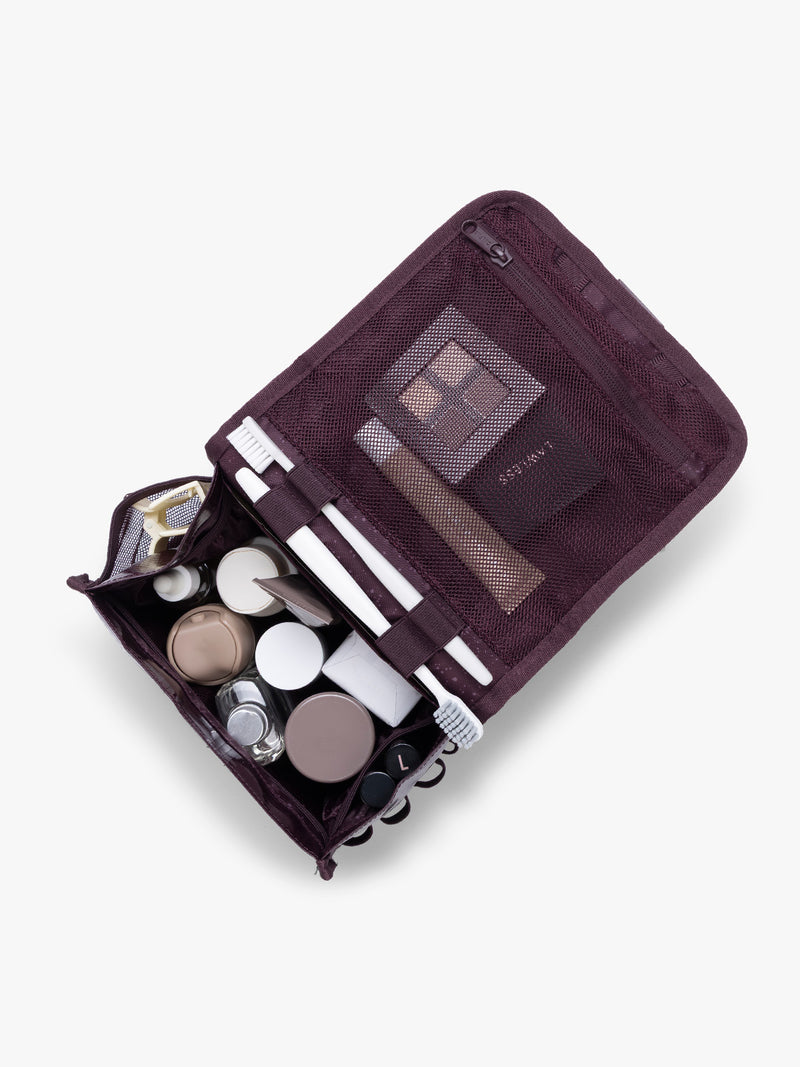 CALPAK Terra Hanging Toiletry Bag  storing makeup and toiletries in dark red  Dark Cherry on a white background