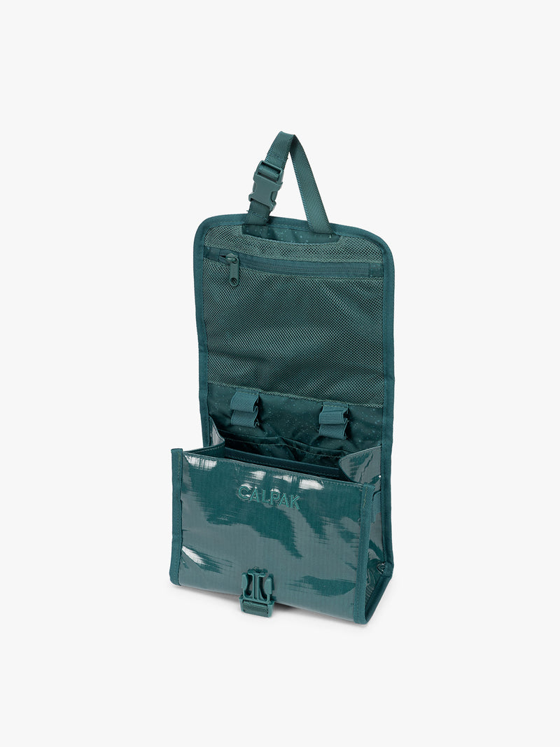 Opened CALPAK Terra Hanging Toiletry Bag to store makeup and toiletries in blue green Kale on a white background