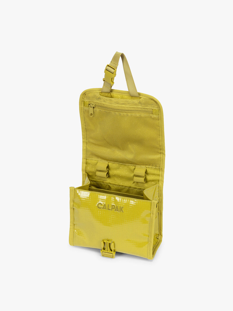 Opened CALPAK Terra Hanging Toiletry Bag to store makeup and toiletries in yellow green Wasabi on a white background
