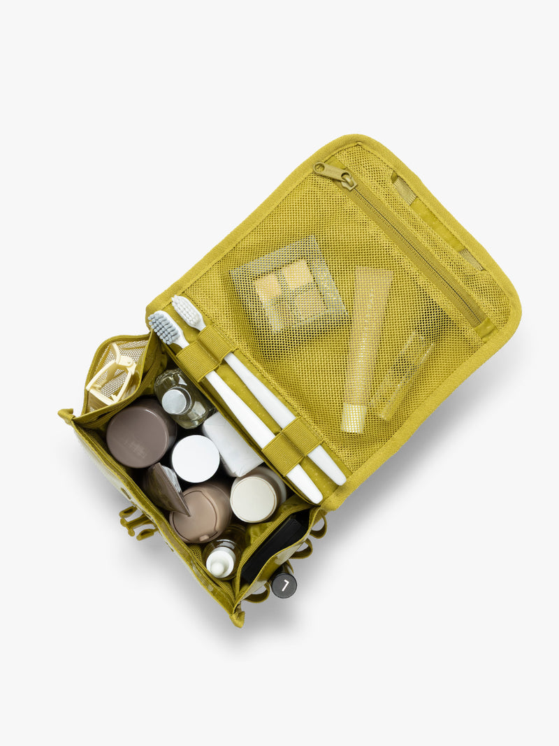 CALPAK Terra Hanging Toiletry Bag storing makeup and toiletries in yellow green Wasabi on a white background